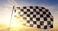 Checkered flag waving against a sunset sky.
