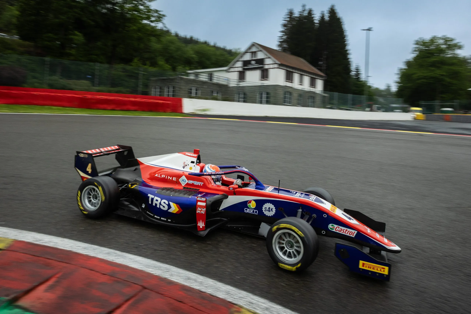 A racing car on track at speed, cornering with blurred background.